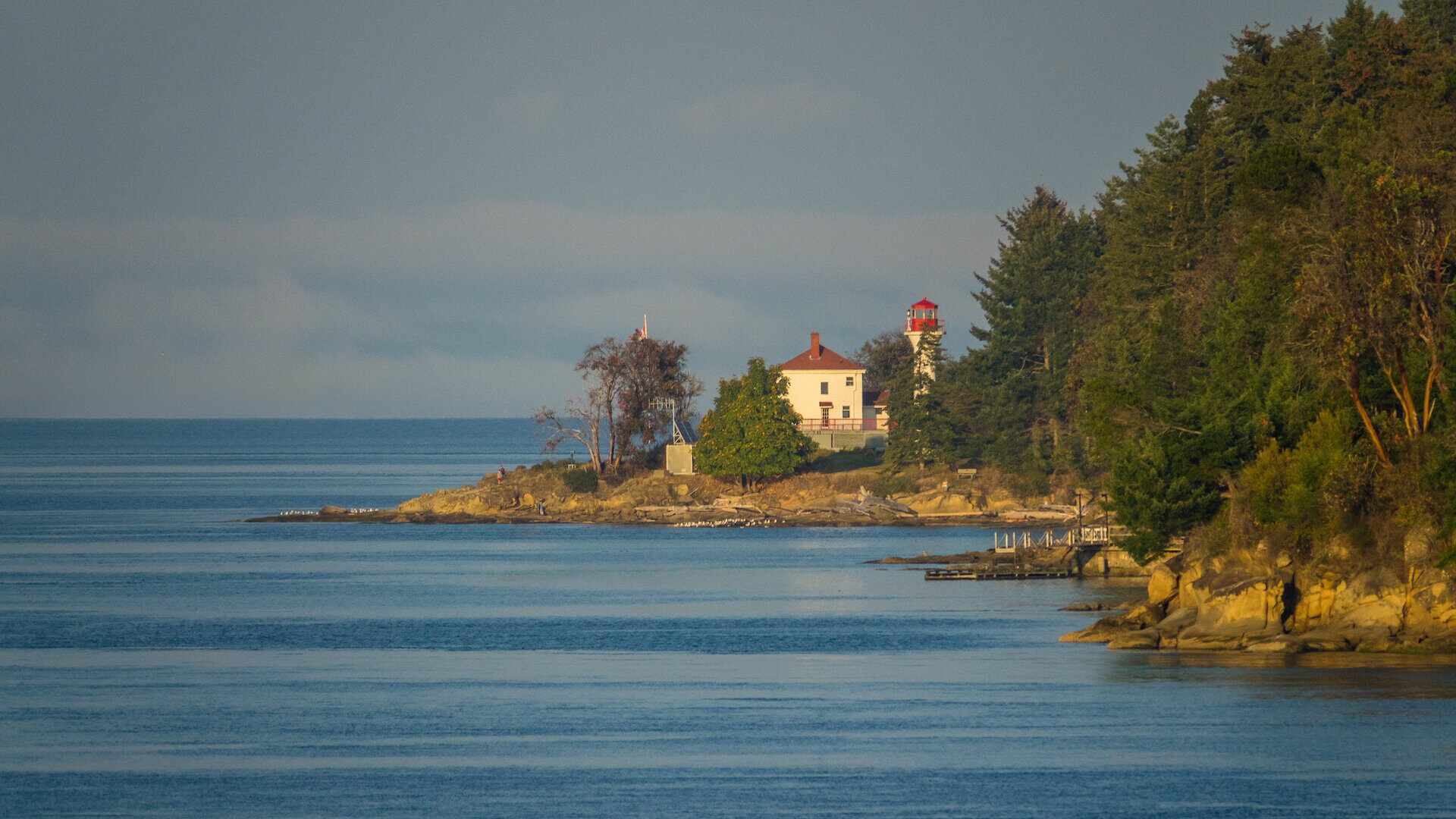 The tranquil waters of Bennett Bay on Mayne Island, with the historic lighthouse in the distance, bathed in soft winter light.<br />
