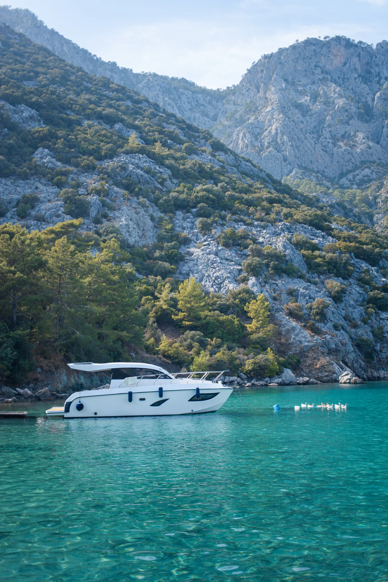 A sleek, modern yacht equipped with hybrid propulsion technology gliding silently through calm waters. This image emphasizes the integration of green technology in yacht design.