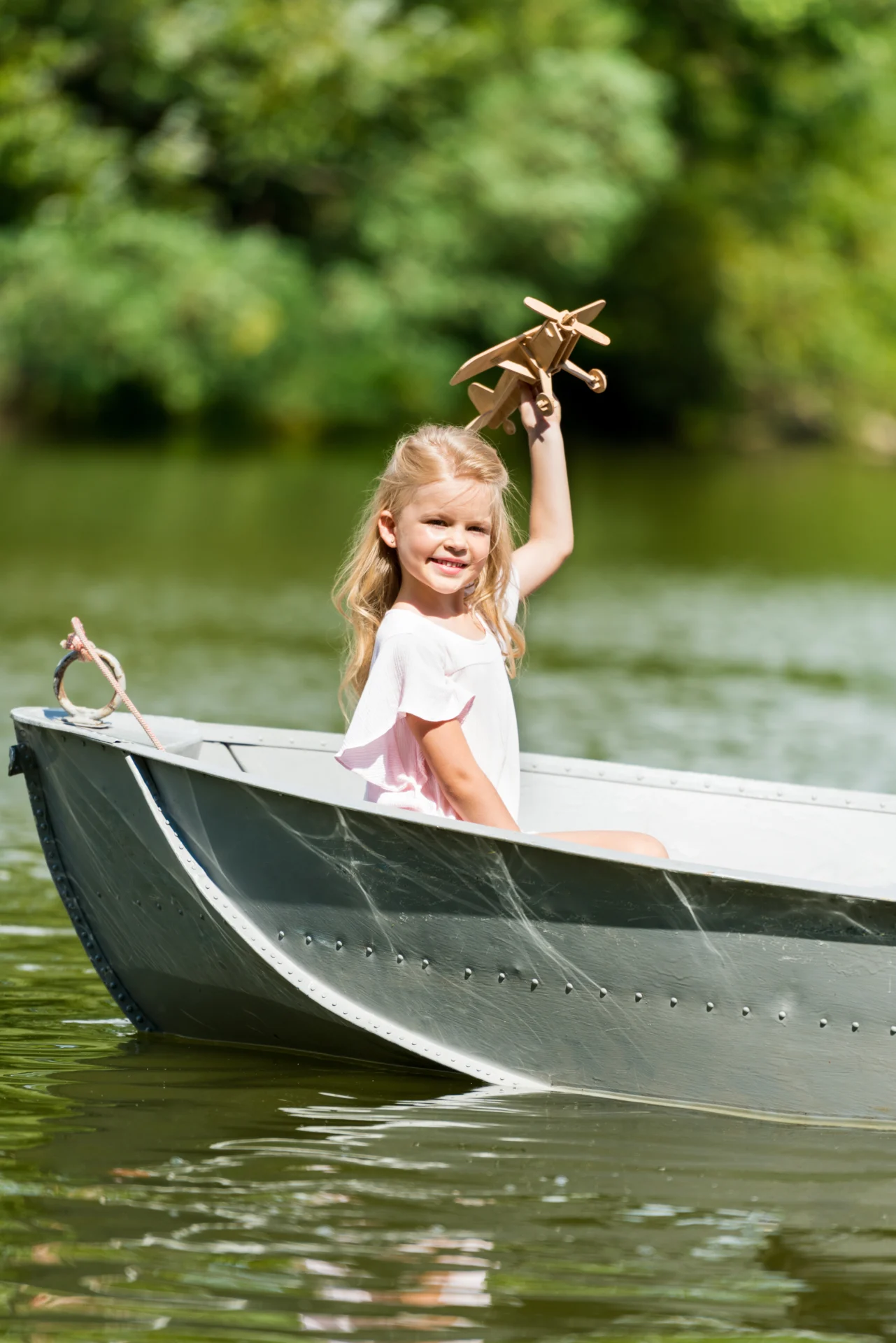 little-child-playing-with-toy-plane-floating-in-boat