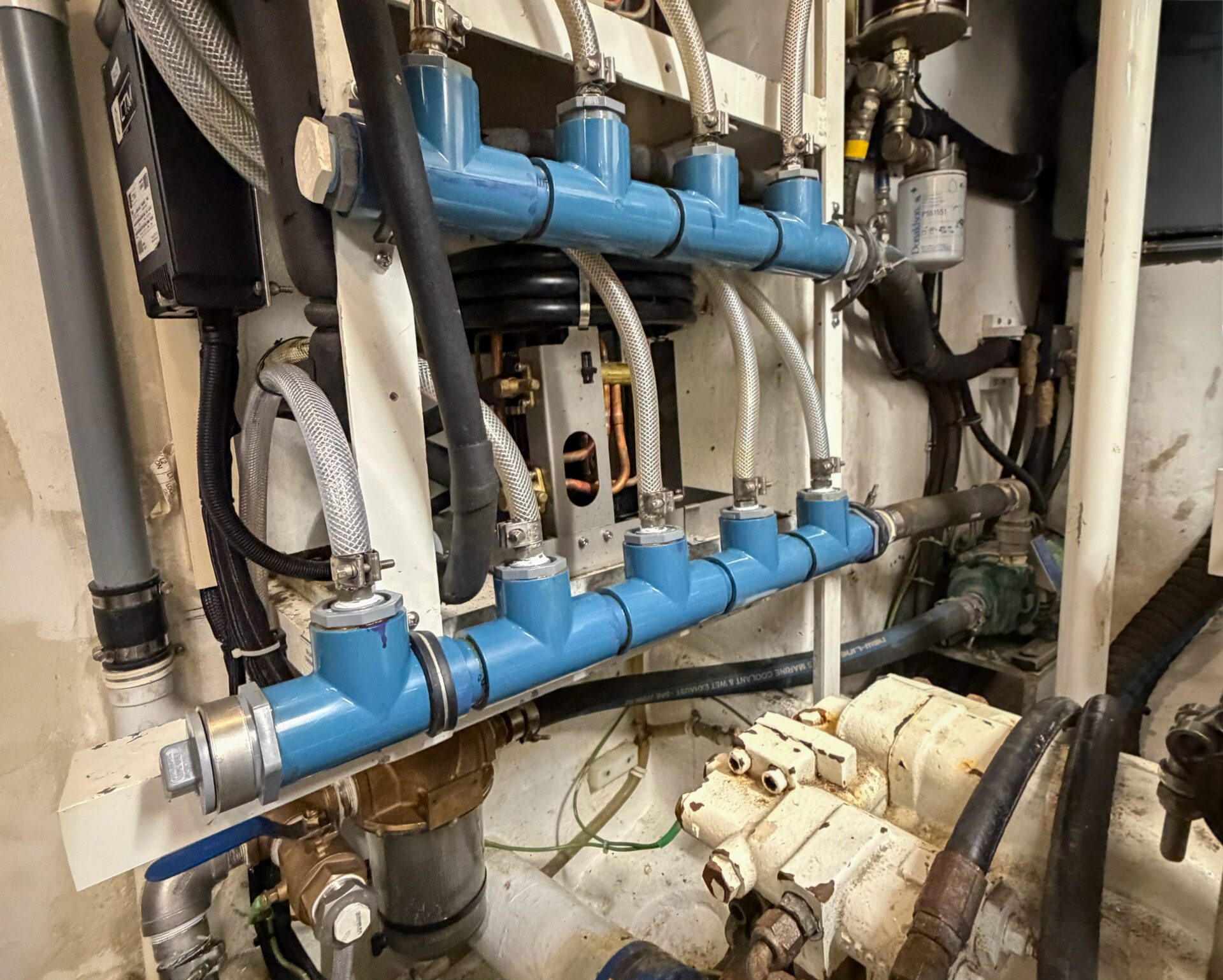 Marine AC flushing system with rebuilt discharge manifold and injection ports
