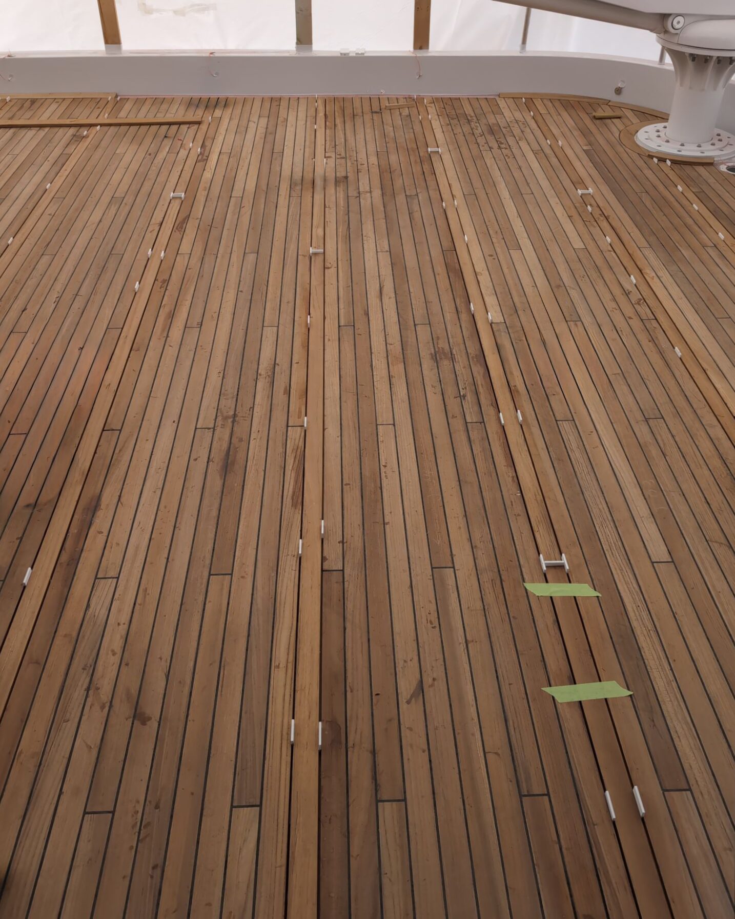 Teak decking sections aligned with spacers during onboard installation