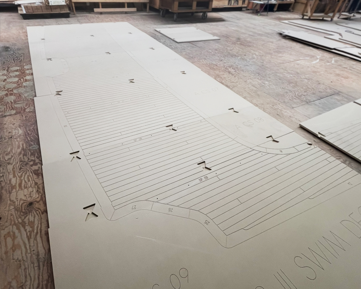 Custom teak decking templating guides arranged as full-scale deck sections