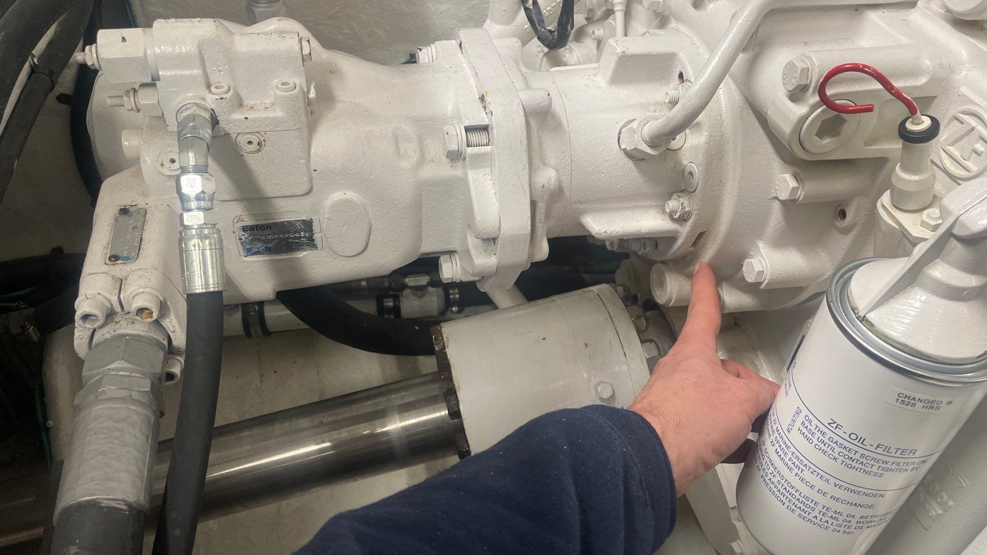 hand pointing to marine engine during a mechanical walkthrough for a yacht refit