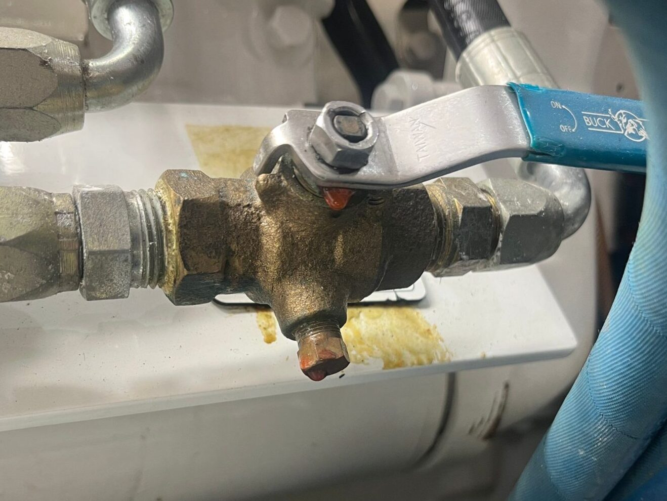 small oil leak on the valve of a boat oil hose