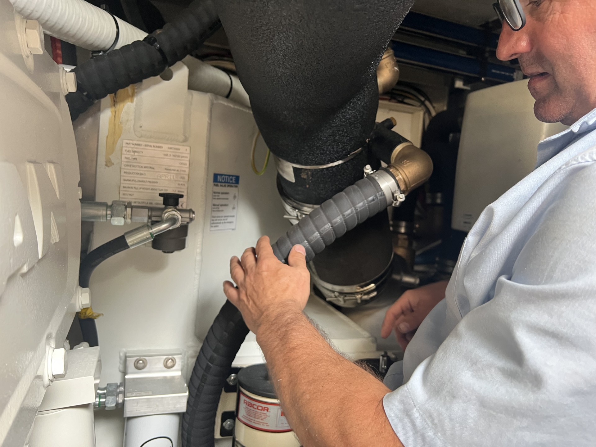 a marine mechanic performing an inspection on an engine room at west bay shipyards