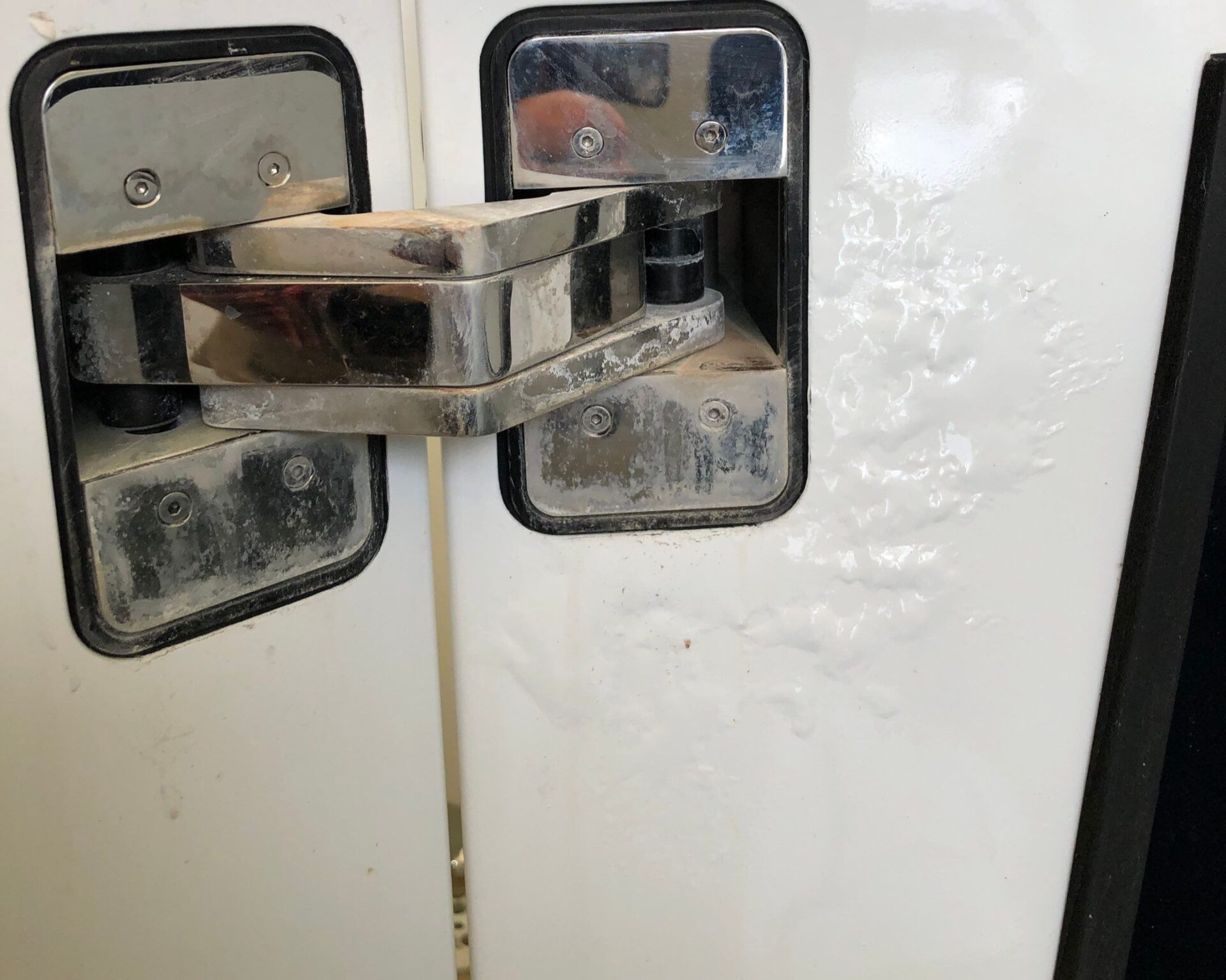 bubbling exterior paint near the hatch hinge on a yacht